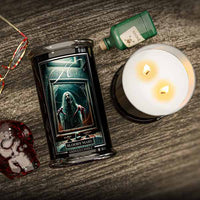 Halloween Candle labeled 'Bloody Mary' next to a lit candle on a wooden surface