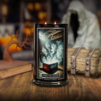 Candle with 'Chest of Chaos' design on a wooden surface with pumpkins and books in the background