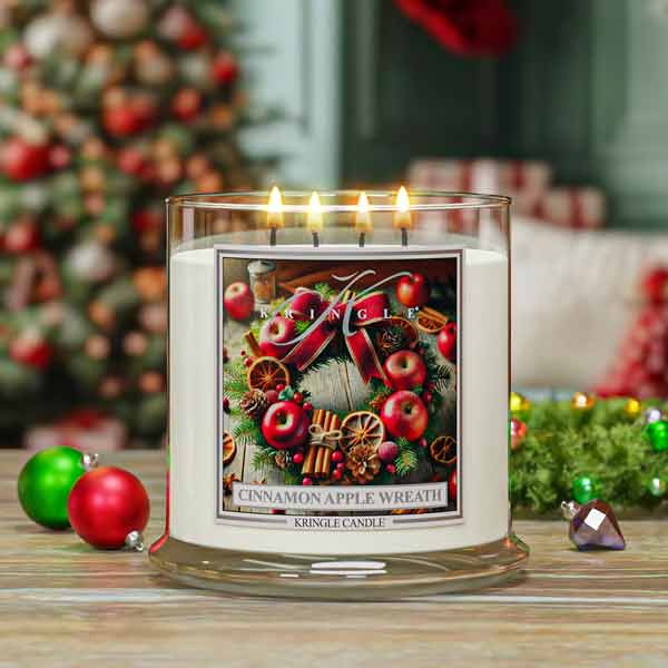Kringle Candle with 'Cinnamon Apple Wreath' design in front of a Christmas tree.
