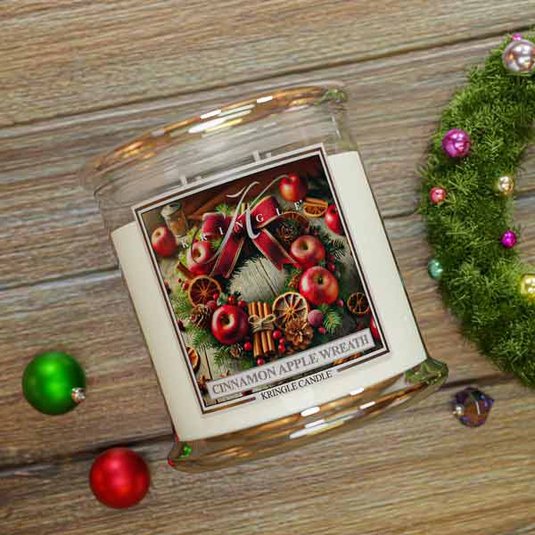 Kringle Candle with Christmas design on a wooden surface with festive decorations.