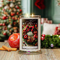 Kringle Candle with Christmas-themed label in front of a decorated Christmas tree.