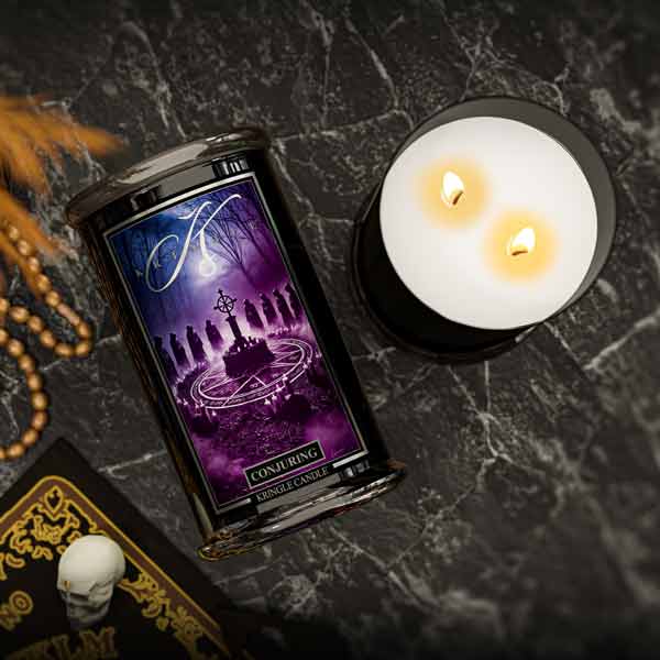 Kringle Halloween Candle with packaging on a dark surface with tarot cards and a skull.