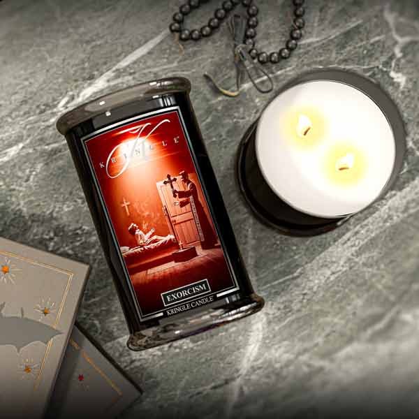 Exorcism-themed Halloween candle with packaging on a gray surface