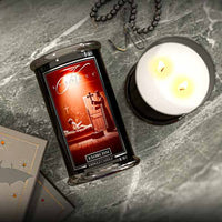 Exorcism-themed Halloween candle with packaging on a gray surface