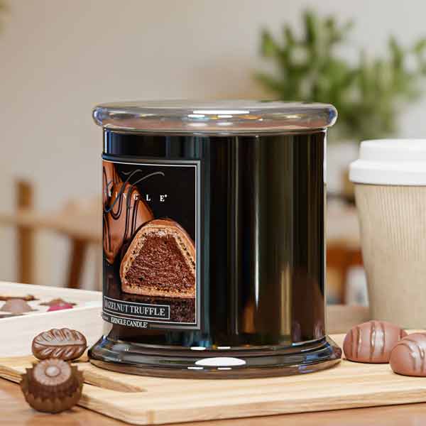 Black candle with a chocolate truffle design on a wooden surface