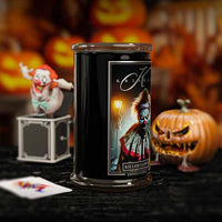 Candle with a 'Killer Clown' design in front of Halloween-themed decorations