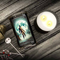 Candle labeled 'Mummy Marshmallow' next to a lit candle on a wooden surface.
