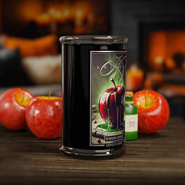 Candle with 'Poison Apple' label featuring an apple design, surrounded by apples and bottles on a wooden surface.