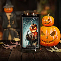 Kringle Candle Pumpkin Head candle with Halloween-themed design and jack-o'-lanterns in the background.