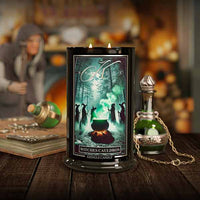 Kringle Candle 'Witches' Cauldron' candle with decorative bottles and books on a wooden surface.