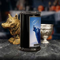 Candle with wolf design on a dark surface with decorative items.