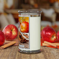 Candle with a 'Spiced Apple' label surrounded by apples and cinnamon sticks on a wooden surface.
