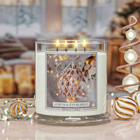 Aurum and Evergreen Lit candle with a decorative holiday label in a festive setting