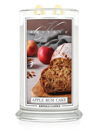 Lit large 2-wick candle with an image of sliced apple rum cake, apples, and nuts on the label.