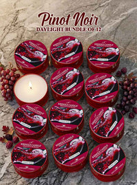 12 Kringle Candle Pinot Noir daylight candles on a stone surface with grapes and leaves.