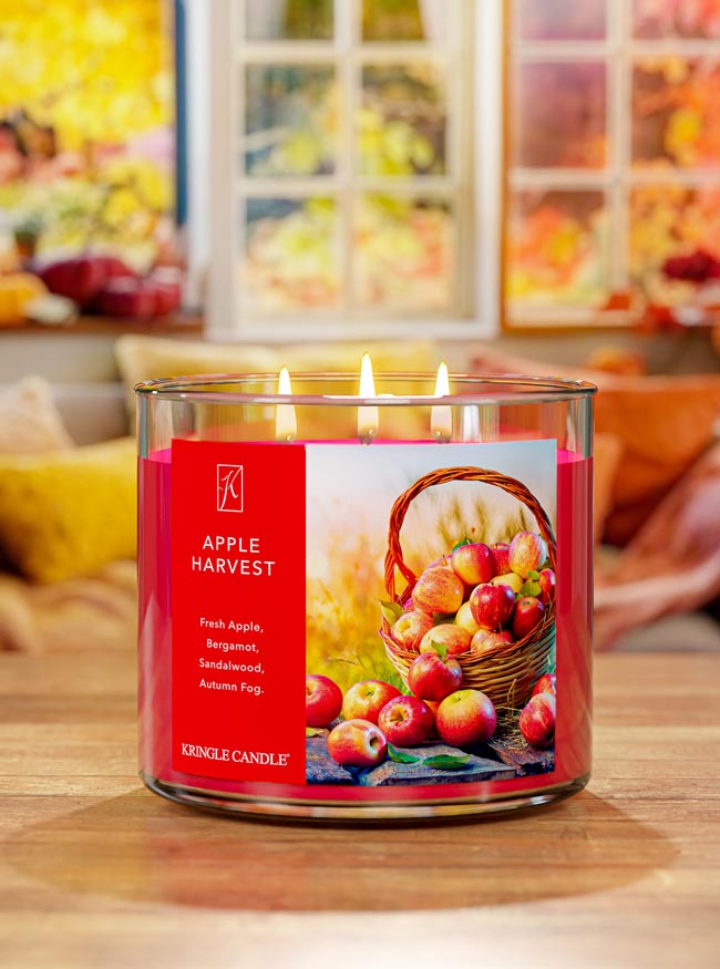 Kringle Candle Apple Harvest candle with a fruit-themed label on a wooden surface.