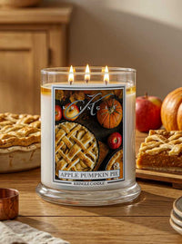 Kringle Candle with 'Apple Pumpkin Pie' label on a table with pie and pumpkins.