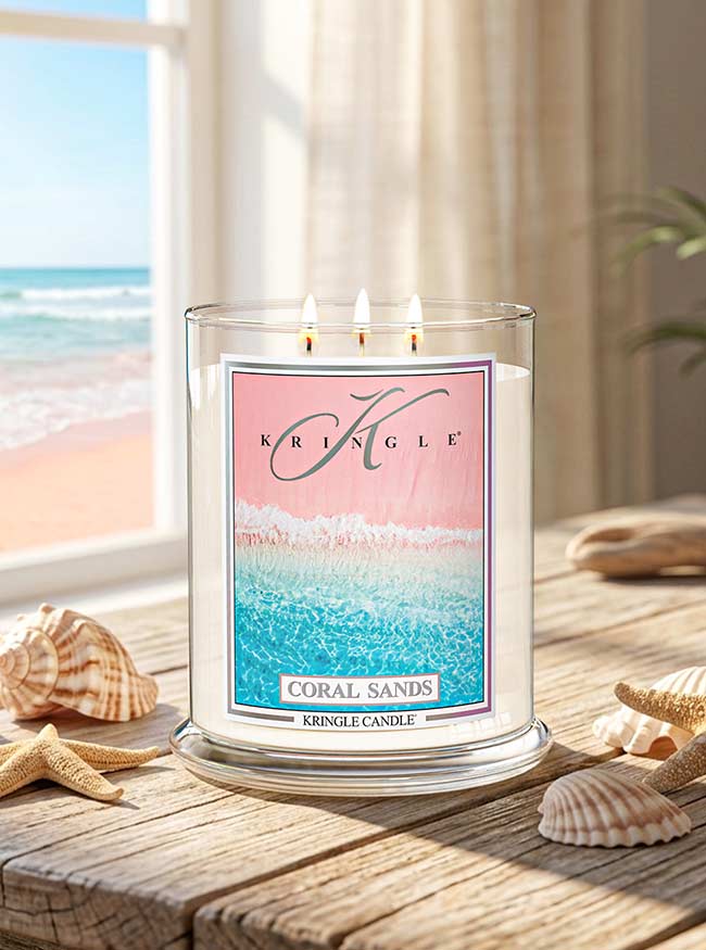 Kringle Candle with 'Coral Sands' design on a beach-themed setting.