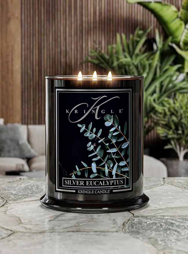Kringle Candle in Silver Eucalyptus on a marble surface with plants in the background