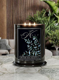 Kringle Candle in Silver Eucalyptus on a marble surface with plants in the background