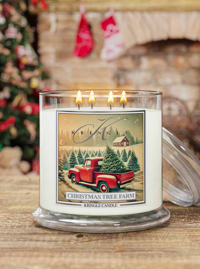Kringle Candle with a Christmas tree farm design in front of a fireplace and Christmas tree.