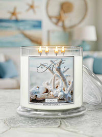 Kringle Candle with coral design candle on a table in a cozy room.