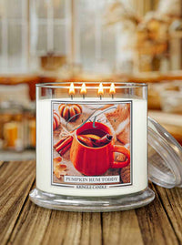 Kringle Candle Pumpkin Rum Toddy 4-wick lit candle with a label with a fall background
