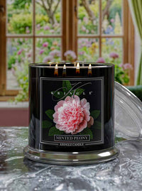 Kringle Candle Minted Peony with pink flower design on a decorative surface with a garden view.
