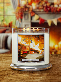 Lit Whiskey & Embers XL 4-Wick candle; label shows fireplace with a whiskey glass and an open book nearby.