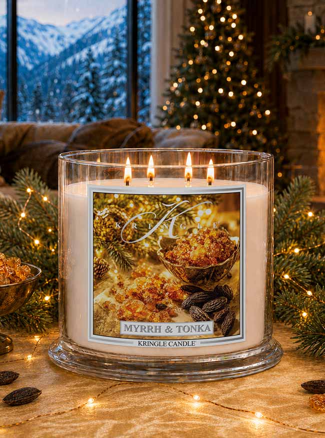 Myrrh & Tonka 4-wick lit candle jar by Kringle Candle in a living room setting with holiday tree and decor.