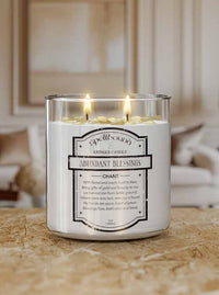 Abundant Blessing Lit Candle with a label on a wooden surface, blurred background