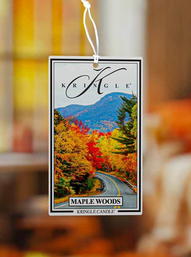Kringle Candle Maple Woods air freshener with a scenic design of trees and mountains.