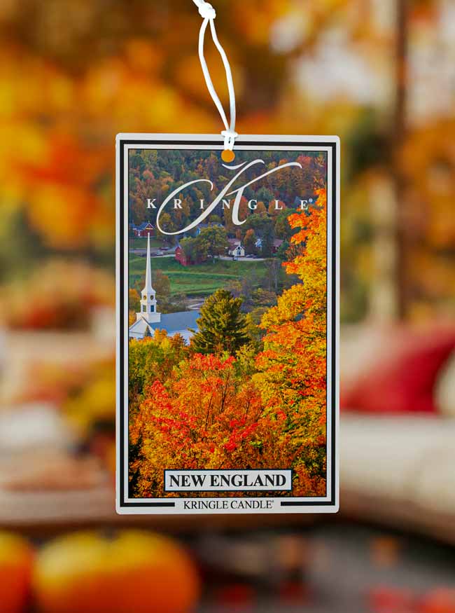 Kringle Candle New England-themed air freshener with a blurred autumn background.