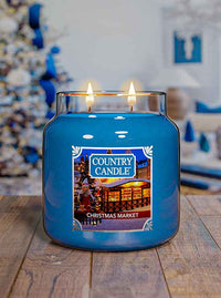 Blue Country Candle Christmas Market scented candle on a wooden surface with a festive background.