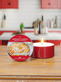 Kringle Candle Apple Cider Cake candle on a wooden surface with a kitchen in the background