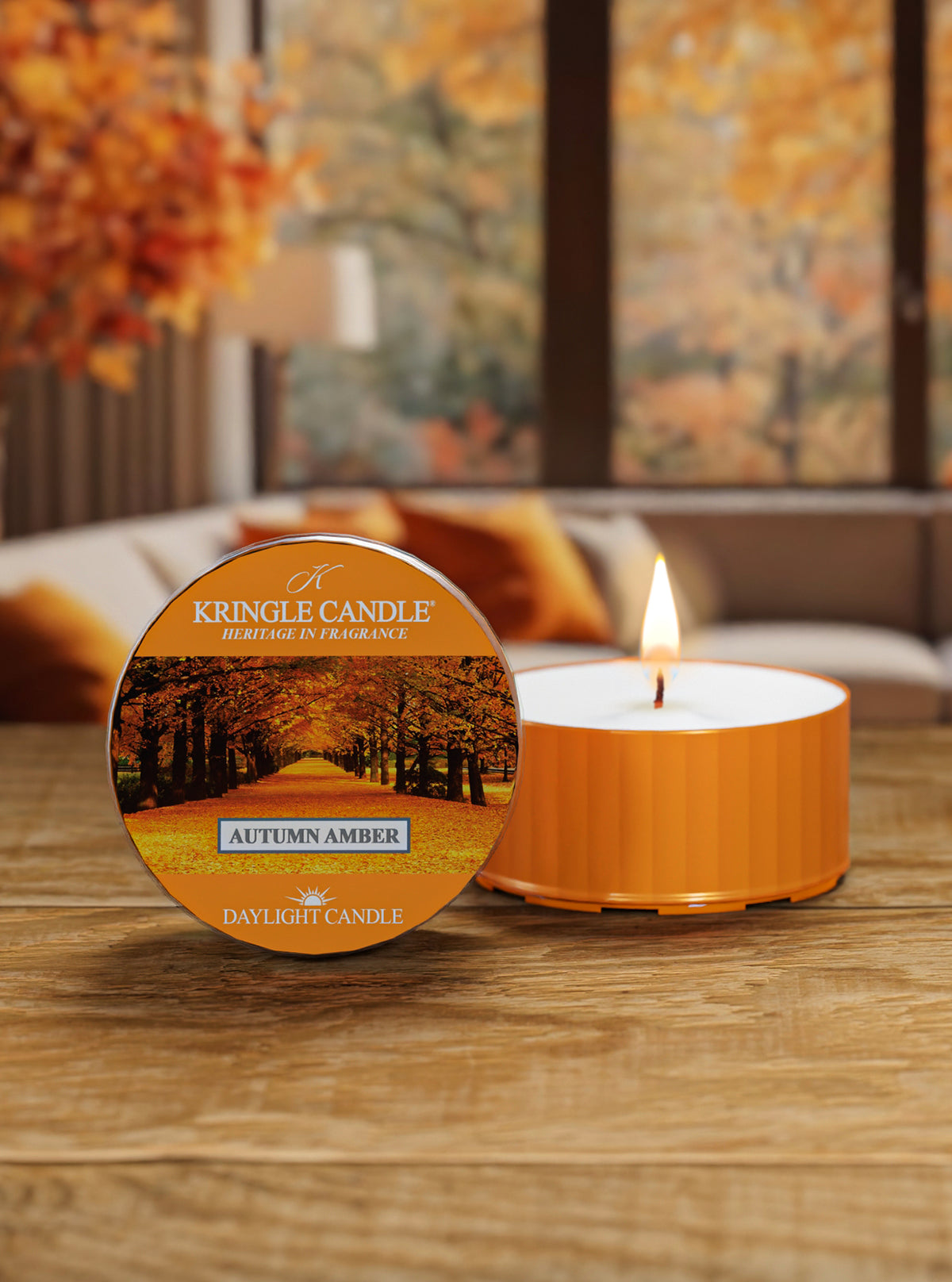 Kingle Candle Autumn Amber candle on a wooden surface with a blurred autumn-themed background