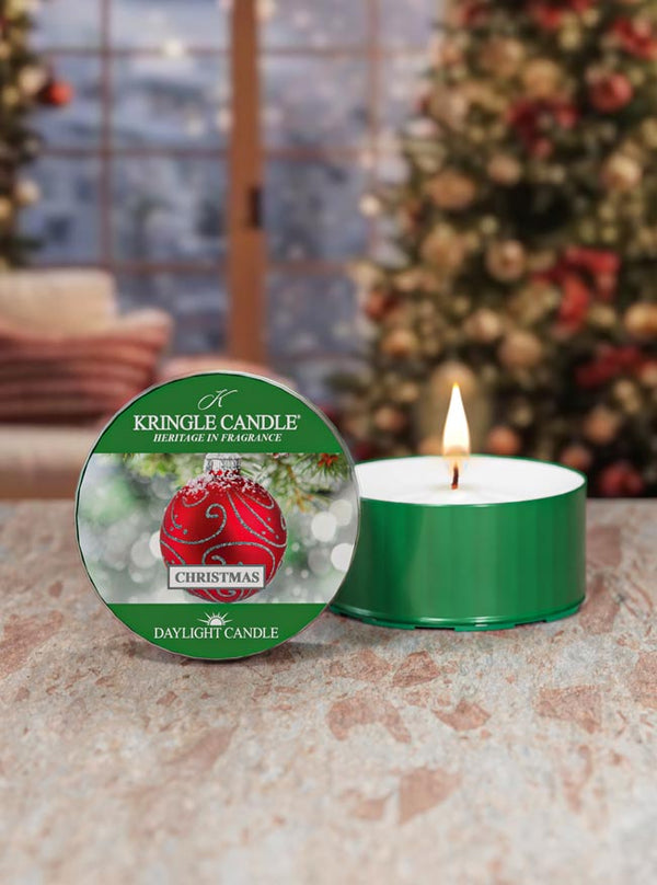 Kringle Candle Christmas scented candle with packaging in front of a decorated Christmas tree.