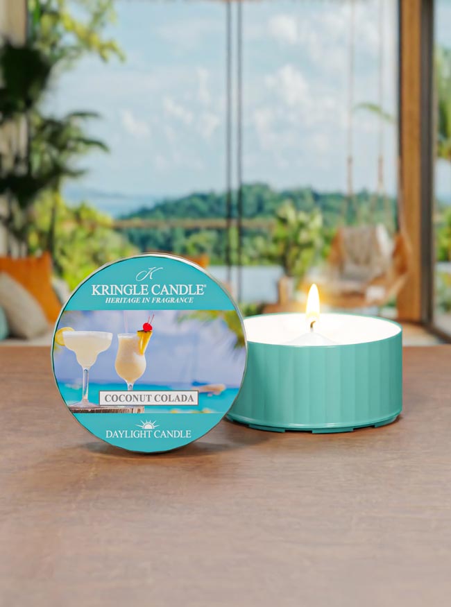 Kringle Candle coconut colada candle on a table with a scenic background