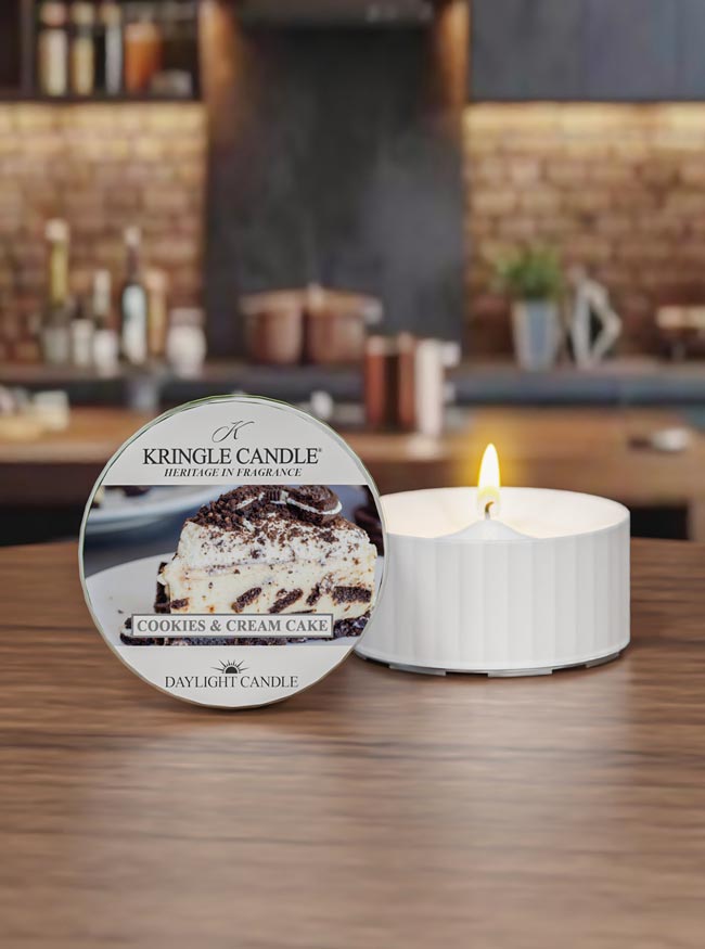Kringle Candle cookies & cream cake scented candle on a wooden surface with a blurred kitchen background