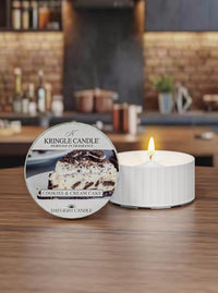 Kringle Candle cookies & cream cake scented candle on a wooden surface with a blurred kitchen background