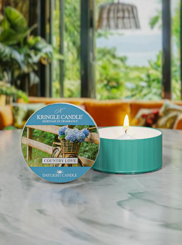 Kringle Candle daylight candle on a marble surface with a scenic background