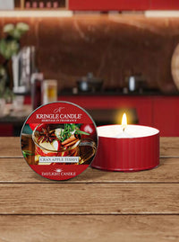 Kringle Candle Cranapple Toddy candle on a wooden surface with a blurred kitchen background