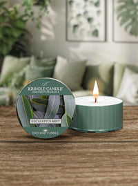 Kringle Candle Eucalyptus Mint candle on a wooden surface with a blurred indoor background