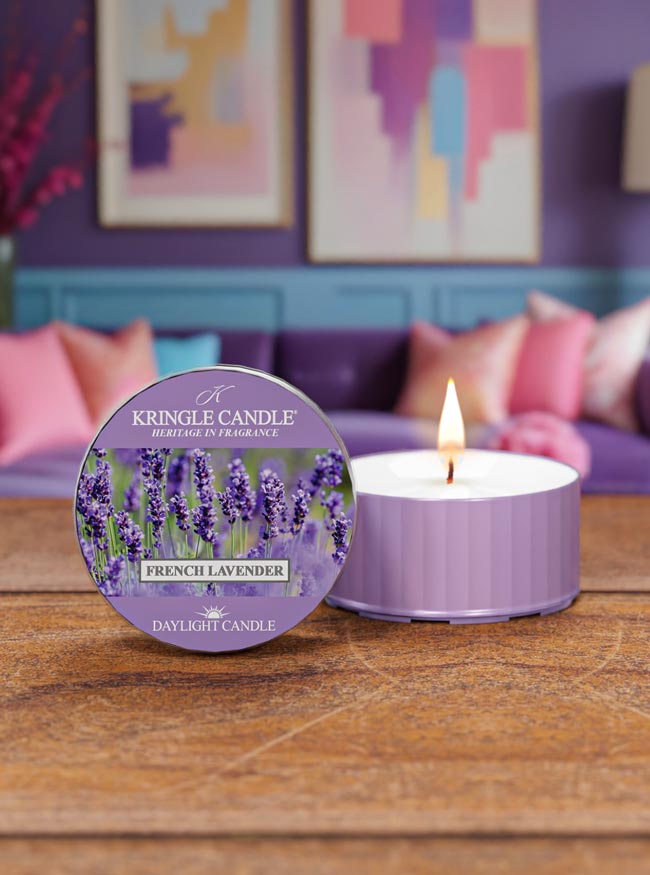 Kringle Candle French Lavender candle on a wooden surface with a colorful abstract painting in the background.