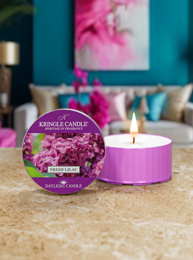 Kringle Candle Fresh Lilac candle on a table with a blurred living room background