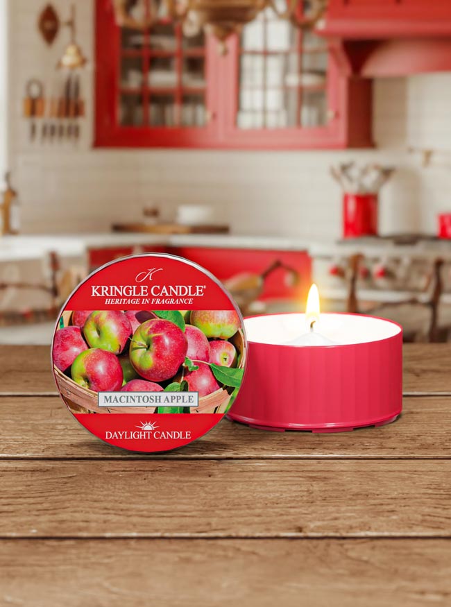 Kringle Candle Macintosh Apple candle on a wooden surface with a kitchen background