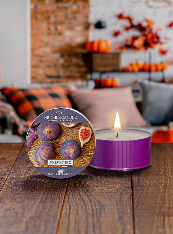 Purple daylight cup, unlit, labeled "Velvet Fig DayLight Candle" with images of figs and fig slices on the lid.