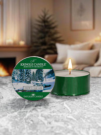 Snowy Cascade  candle with Kringle Candle packaging on a textured surface with a cozy indoor background.