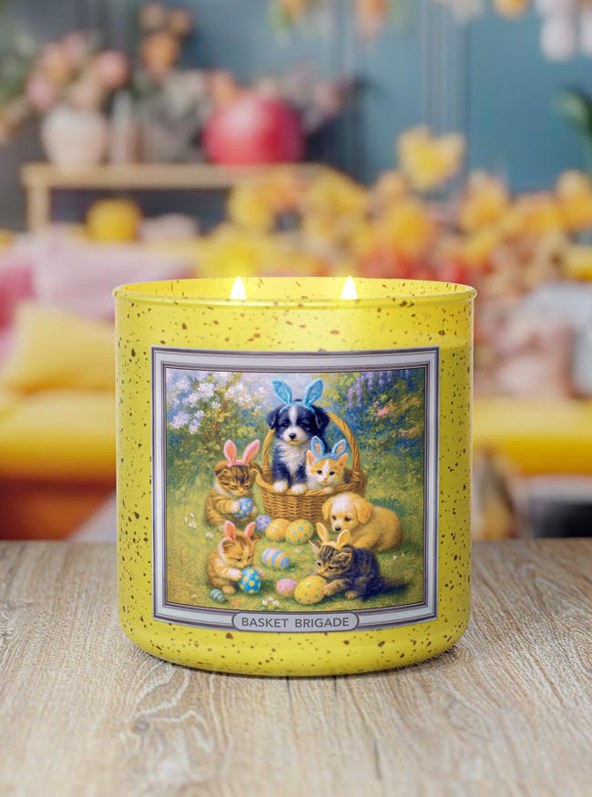 Yellow candle with a decorative label featuring animals and Easter elements on a wooden surface.
