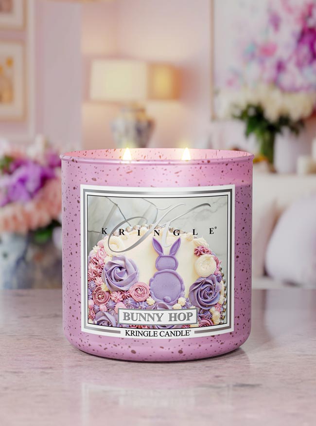 Kringle Candle Easter-themed candle on a table with blurred floral background